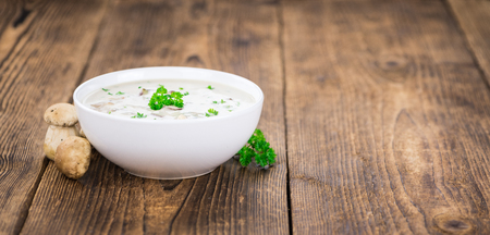 Homemade Porcini Soup on an wooden table as detailed close-up shot; selective focusの写真素材