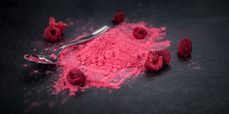 Some Raspberry powder on a slate slab as detailed close-up shot; selective focusの写真素材