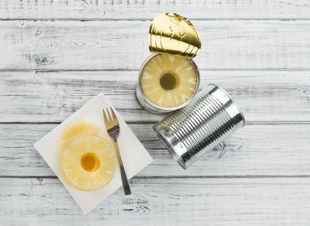 Preserved Pineapple Rings as high detailed close-up shot on a vintage wooden table; selective focusの写真素材