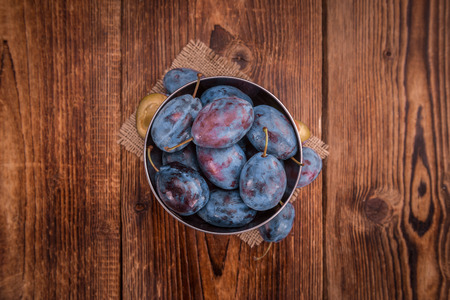 Plums on a vintage background as detailed close-up shot, selective focusの写真素材