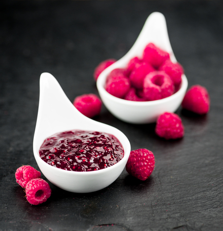 Portion of Raspberry Jam on a rustic slate slab, selective focus, close-up shot