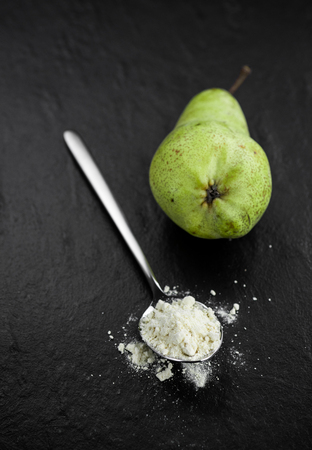 Portion of fresh made Pear powder on a slate slab (selective focus)の写真素材