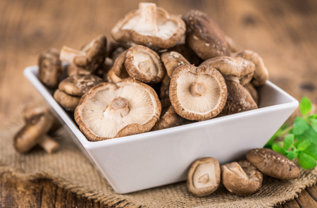 Raw Shiitake mushrooms as high detailed close-up shot on a vintage wooden table; selective focusの写真素材