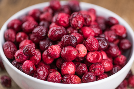 Dried Cranberries on an old wooden table (selective focus)の写真素材