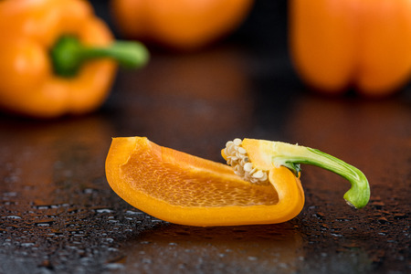 Fresh made Orange paprika on a slate slab (close-up shot; selective focus)の写真素材