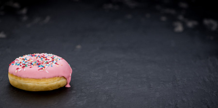 Portion of pink glazed Donuts (detailed close-up shot)の写真素材