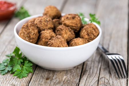 Old wooden table with fresh homemade Meatballs (close-up shot; selective focus)の写真素材