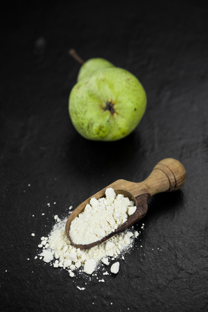 Portion of fresh made Pear powder on a slate slab (selective focus)の写真素材