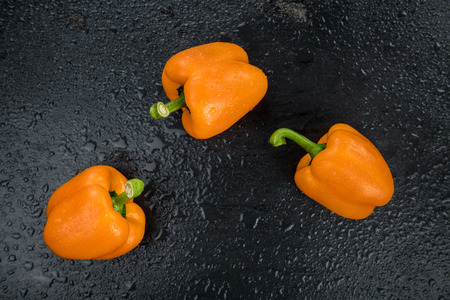 Some healthy Orange paprika on a vintage slate slab (selective focus)の写真素材