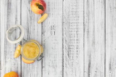 Old wooden table with fresh made Applesauce (selective focus; close-up shot)の写真素材