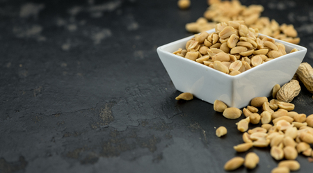 Roasted Peanuts on a vintage slate slab (selective focus; close-up shot)