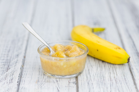 Banana Puree on wooden background (selective focus; close-up shot)の写真素材