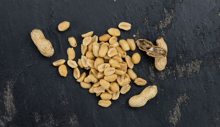 Portion of roasted and salted  Peanuts (close-up shot; selective focus)