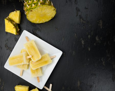 Some homemade Pineapple Popsicles (selective focus) on a rustic backgroundの写真素材