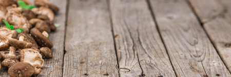 Shiitake mushrooms on an old wooden table as detailed close-up shot; selective focusの写真素材