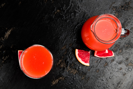 Some freshly squeezed Grapefruit Juice on a vintage background (close-up shot; selective focus)の写真素材
