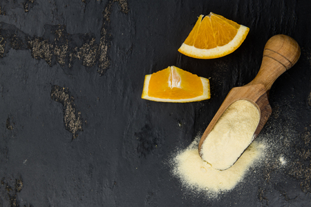 Orange fruit powder on a slate slab (selective focus; close-uo shot)の写真素材