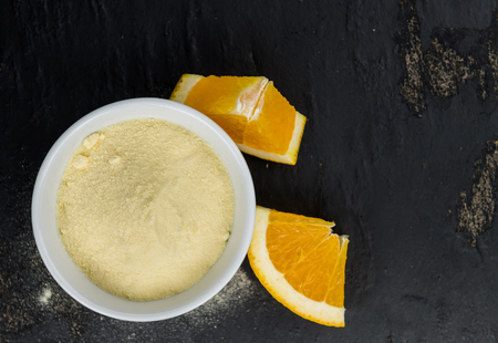 Orange fruit powder on a slate slab (selective focus; close-uo shot)の写真素材