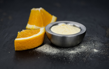 Orange fruit powder on a slate slab (selective focus; close-uo shot)の写真素材