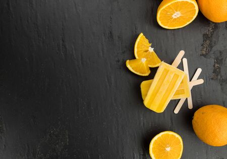 Some fresh made orange ice creams on a slate slab (selective focus; close-up shot)の写真素材