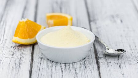 An old wooden table with orange fruit powder (selective focus)の写真素材