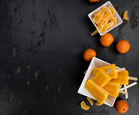 Slate slab with homemade Tangerine ice creams (selective focus) as detailed close-up shot