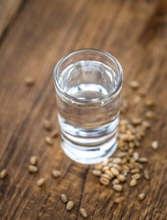 Vintage wooden table with Wheat Liqueur (selective focus; close-up shot)の写真素材