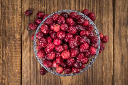 Dried Cranberries on an old wooden table (selective focus)の写真素材