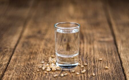 Wooden table with Wheat Liqueur (detailed close-up shot; selective focus)の写真素材