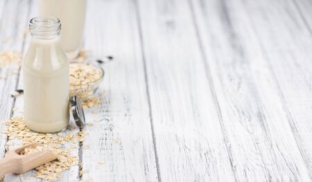 Healthy Oat Milk on a wooden table as detailed close-up shot (selective focus)の写真素材
