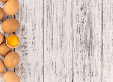 Old wooden table with fresh Raw Eggs (close-up shot; selective focus)の写真素材