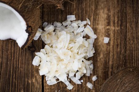 Healthy Coconut Flakes on a wooden table as detailed close-up shot (selective focus)の写真素材