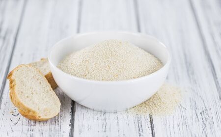Some Bread Crumbs on a vintage wooden table (selective focus; close-up shot)の写真素材