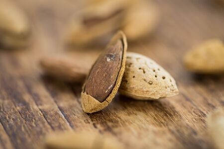 Almonds in shell (roasted and salted) on a vintage background (close-up shot)の写真素材