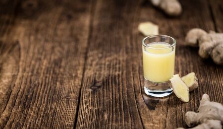 Healthy Ginger Sap on a wooden table as detailed close-up shot (selective focus)の写真素材
