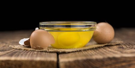 Some Raw Eggs on a vintage wooden table (selective focus; close-up shot)の写真素材