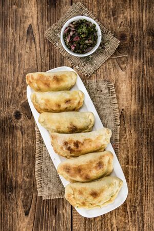 Portion of healthy Empanadas on an old wooden table (selective focus; close-up shot)の写真素材