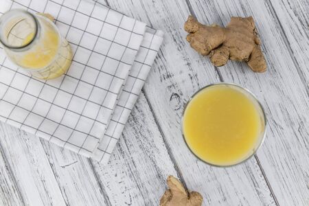 Portion of fresh Ginger Juice (selective focus; close-up shot)