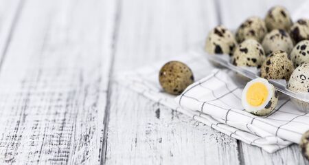 Wooden table with Quail Eggs (detailed close-up shot; selective focus)
