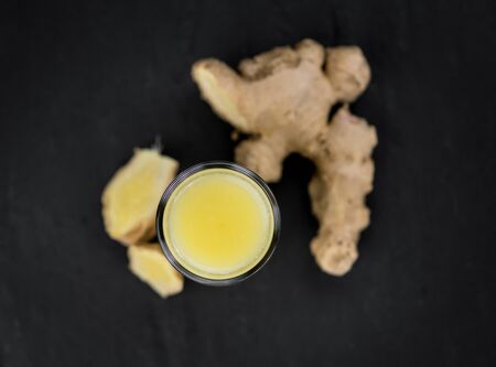 Fresh made Ginger Drink on a slate slab (close-up shot; selective focus)	の写真素材