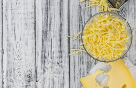Old wooden table with grated Cheese (close-up shot)の写真素材