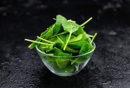 Portion of fresh Spinach as detailed close-up shot on a vintage slate slab (selective focus)の写真素材