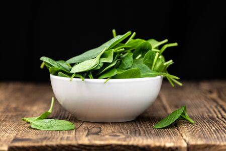 Vintage looking wooden table with fresh Spinach as detailed selective focus (close-up shot)の写真素材