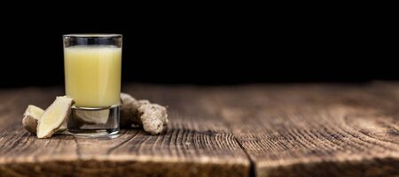 Healthy Ginger Sap on a wooden table as detailed close-up shot (selective focus)の写真素材