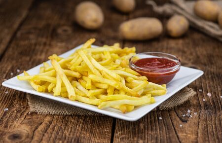 Portion of fresh made crispy French Fries (selective focus; close-up shot)