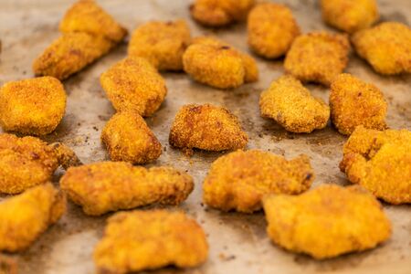 Vintage wooden table with fresh made Chicken Nuggets (close-up shot; selective focus)