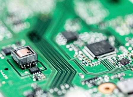 Green printed circuit board (PCB) close-up shot with a lot of electronic components