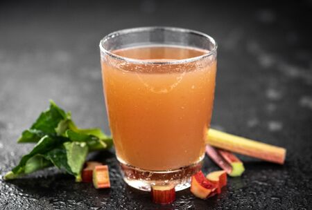 Rhubarb Juice on a rustic background (close up shot; selective focus)の写真素材