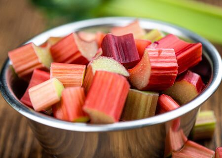 Chopped Rhubarb on an old wooden table (close up shot; selective focus)