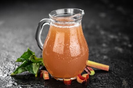 Rhubarb Juice on a rustic background (close up shot; selective focus)